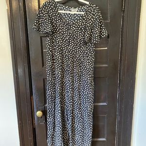 Black onesie/jumpsuit with white flower pattern and buttons down the front